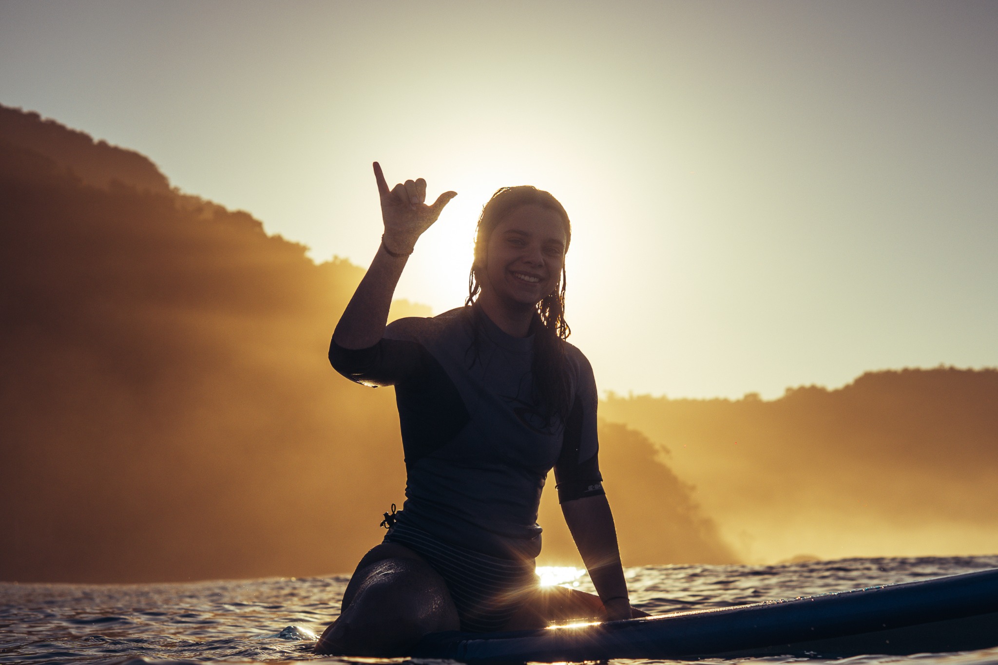 Surfista no mar sob a luz do sol